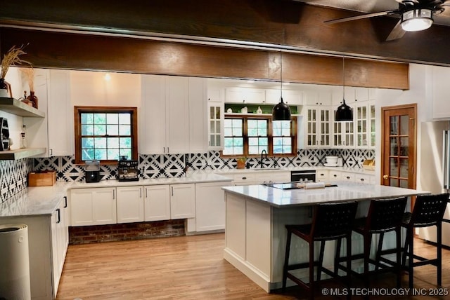 15373 N Javine Hill Rd, Skiatook, OK 74070 - kitchen featuring open shelves, white cabinetry, decorative backsplash, a breakfast bar area, and a ceiling fan