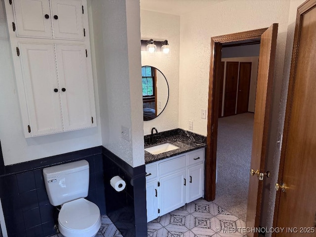 15373 N Javine Hill Rd, Skiatook, OK 74070 - bathroom with vanity, a wainscoted wall, and tile walls