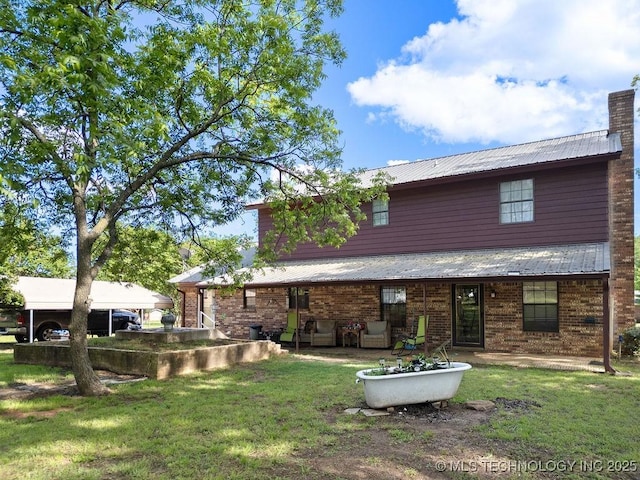 311 Washington Ave, Boswell, OK 74727 - rear view of property with a yard, a patio, metal roof, and brick siding