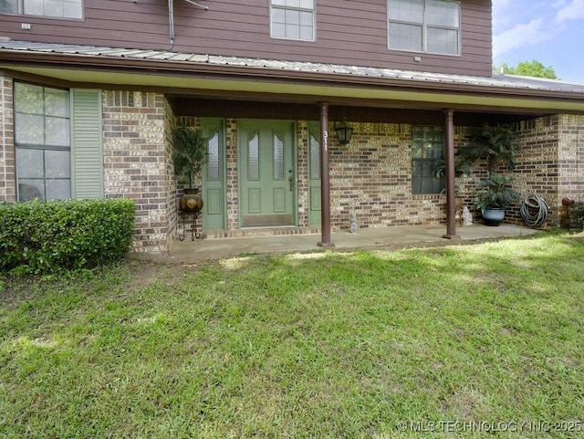 311 Washington Ave, Boswell, OK 74727 - property entrance featuring brick siding, a lawn, and metal roof