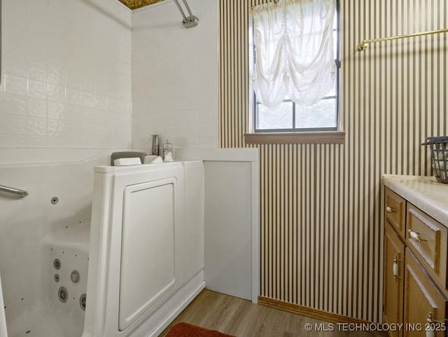 311 Washington Ave, Boswell, OK 74727 - bathroom with a jetted tub, wood finished floors, and vanity