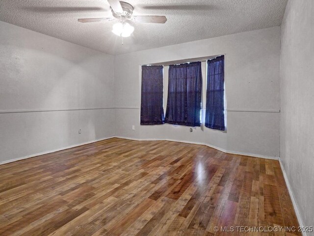 311 Washington Ave, Boswell, OK 74727 - unfurnished room with a textured ceiling, a ceiling fan, wood finished floors, and baseboards