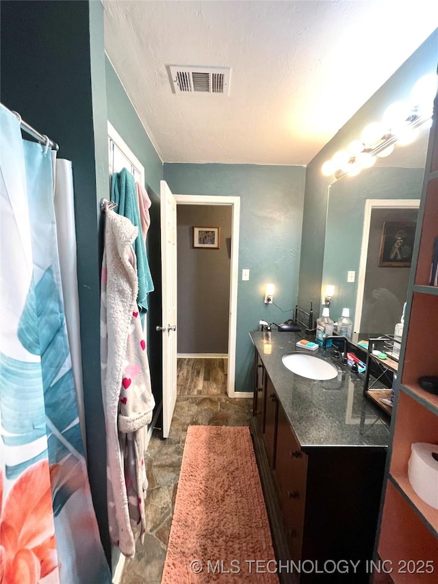 1715 Worley, Durant, OK 74701 - bathroom featuring vanity, stone finish flooring, and a textured ceiling
