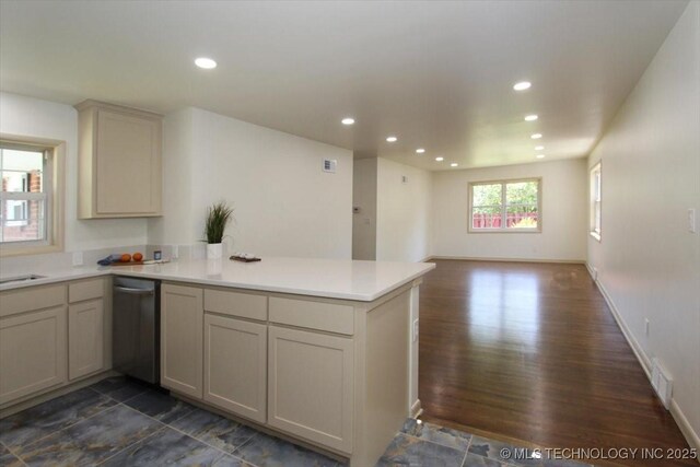 6112 E 21st St, Tulsa, OK 74114 - kitchen with stainless steel dishwasher, a peninsula, light countertops, open floor plan, and dark wood-type flooring