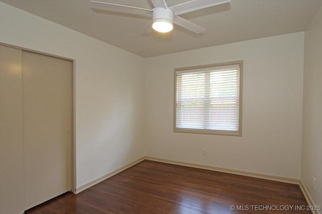 6112 E 21st St, Tulsa, OK 74114 - unfurnished bedroom with dark wood-type flooring, a closet, baseboards, and ceiling fan