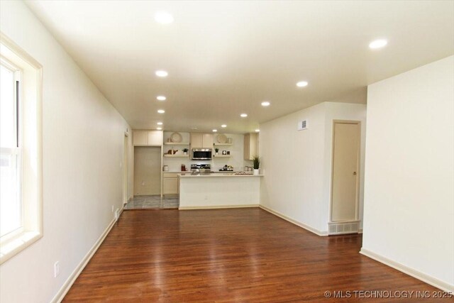 6112 E 21st St, Tulsa, OK 74114 - unfurnished living room featuring wood finished floors, recessed lighting, and baseboards