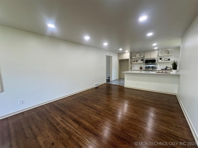 6112 E 21st St, Tulsa, OK 74114 - unfurnished living room featuring dark wood-style flooring, baseboards, and recessed lighting