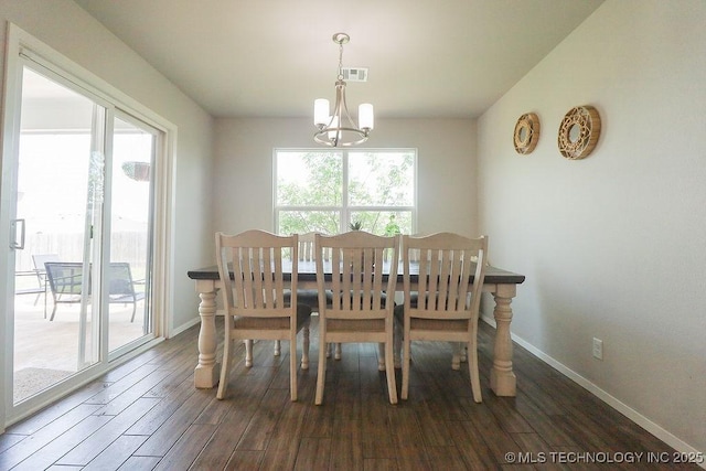 dining space featuring a chandelier, dark wood-style floors, and baseboards