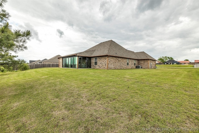 2621 S Catalayah Ln, Claremore, OK 74019 - back of house featuring a sunroom, brick siding, and roof with shingles