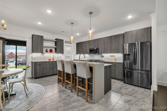 2621 S Catalayah Ln, Claremore, OK 74019 - kitchen featuring stainless steel appliances, open shelves, decorative backsplash, light countertops, and a breakfast bar