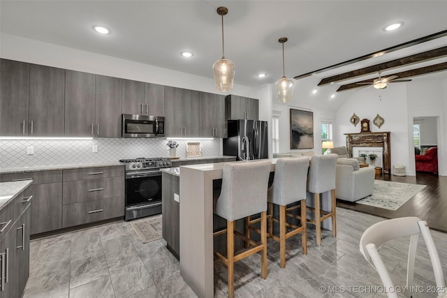2621 S Catalayah Ln, Claremore, OK 74019 - kitchen with appliances with stainless steel finishes, a kitchen breakfast bar, backsplash, a center island, and ceiling fan