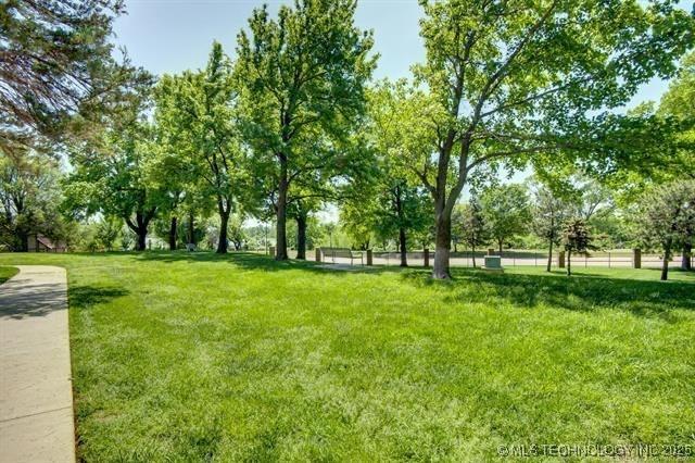 surrounding community featuring a yard and view of wooded area