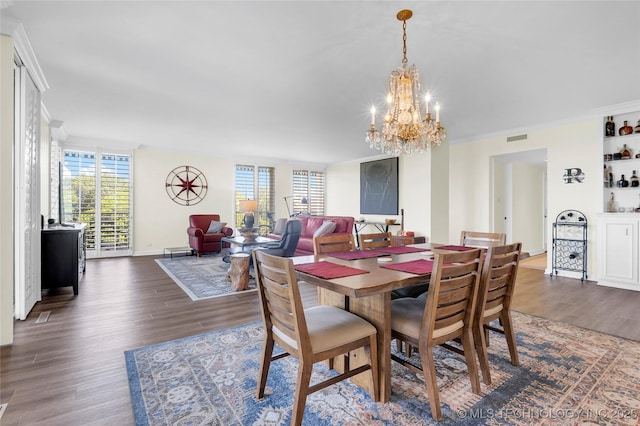 dining room with a chandelier, plenty of natural light, dark wood-style flooring, and ornamental molding