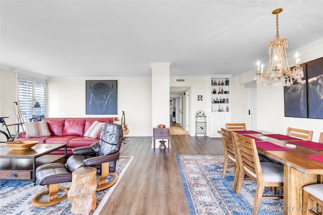 dining space featuring a chandelier, wood finished floors, and crown molding