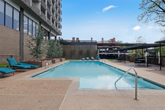 community pool featuring a patio area and a fenced backyard
