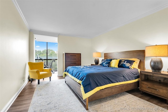 bedroom featuring ornamental molding, wood finished floors, access to outside, baseboards, and expansive windows