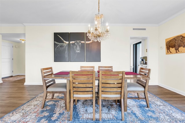 dining space featuring dark wood-style floors, a chandelier, baseboards, and ornamental molding
