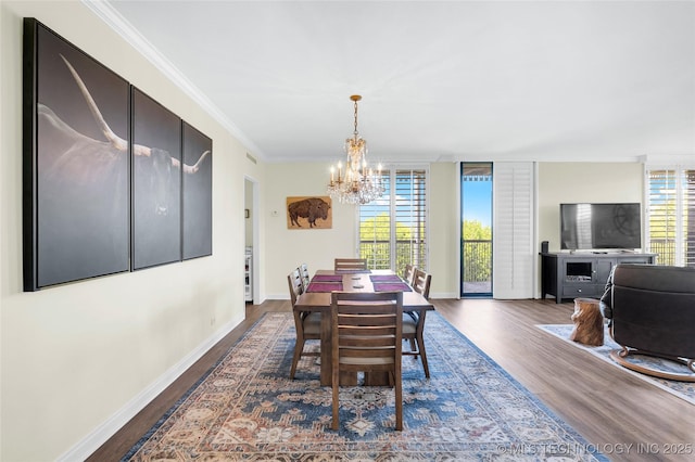 dining area featuring a chandelier, dark wood-type flooring, plenty of natural light, crown molding, and baseboards