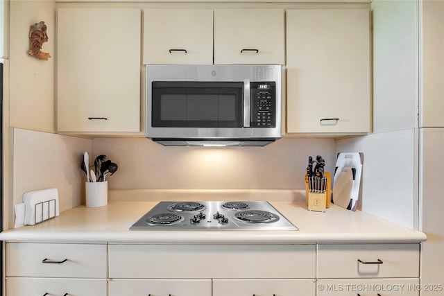 kitchen with appliances with stainless steel finishes, light countertops, and white cabinets