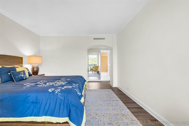 bedroom featuring arched walkways, ornamental molding, baseboards, and dark wood finished floors