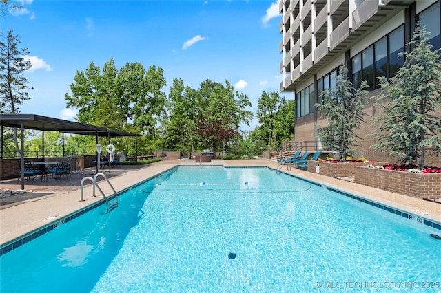 community pool with fence and a patio area