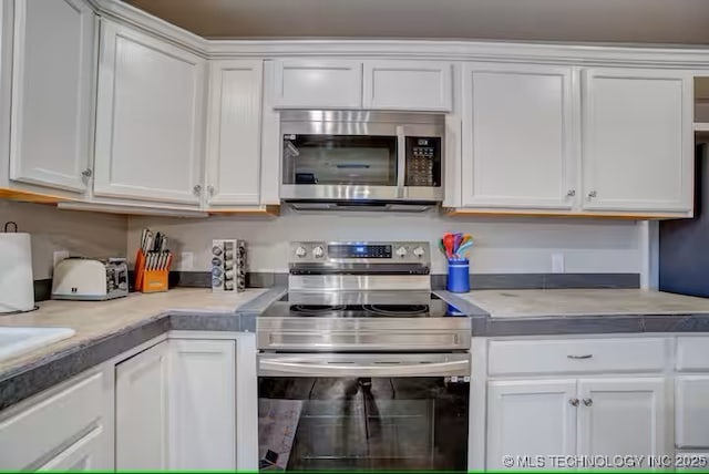 555 Williams Dr, Eufaula, OK 74432 - kitchen featuring appliances with stainless steel finishes, white cabinetry, and light countertops