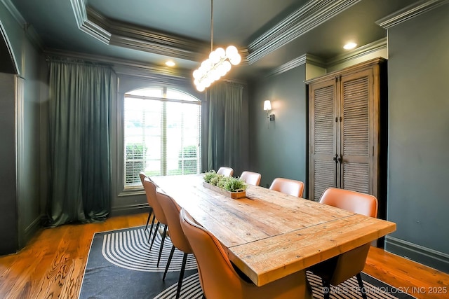 dining space featuring crown molding, wood finished floors, and a chandelier