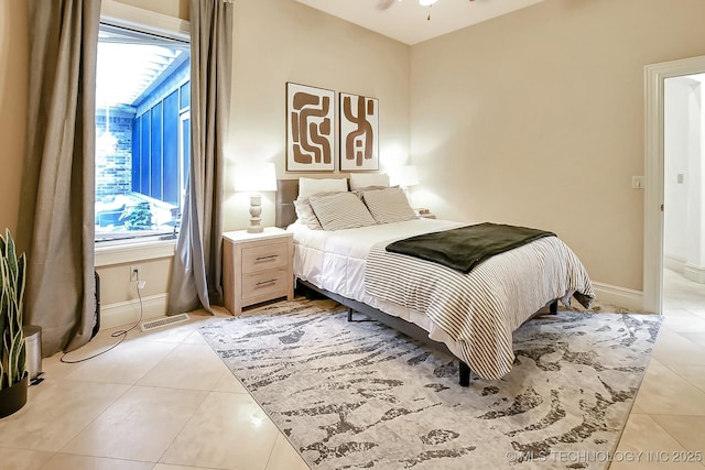 bedroom with light tile patterned flooring and baseboards