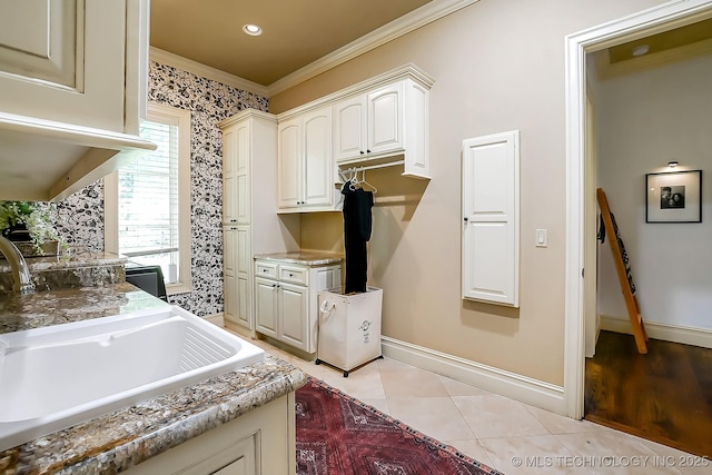 laundry area with ornamental molding, baseboards, and light tile patterned floors