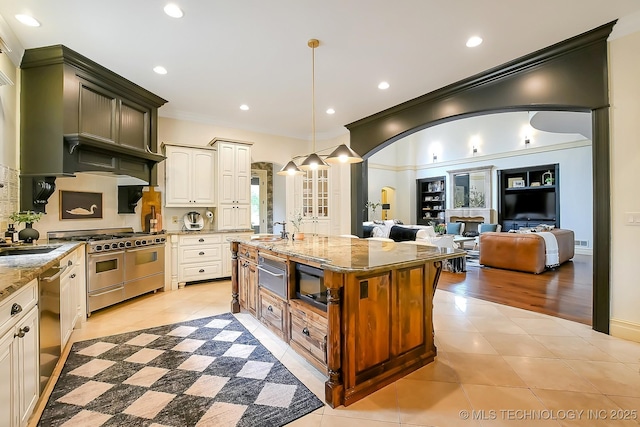 kitchen featuring appliances with stainless steel finishes, light tile patterned floors, a warming drawer, light stone countertops, and recessed lighting