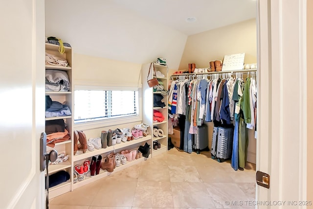 walk in closet with lofted ceiling and tile patterned flooring