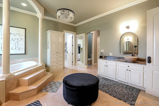 bathroom featuring tile patterned flooring, crown molding, toilet, a bath, and vanity