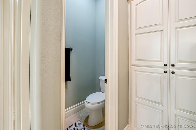 bathroom featuring baseboards and toilet