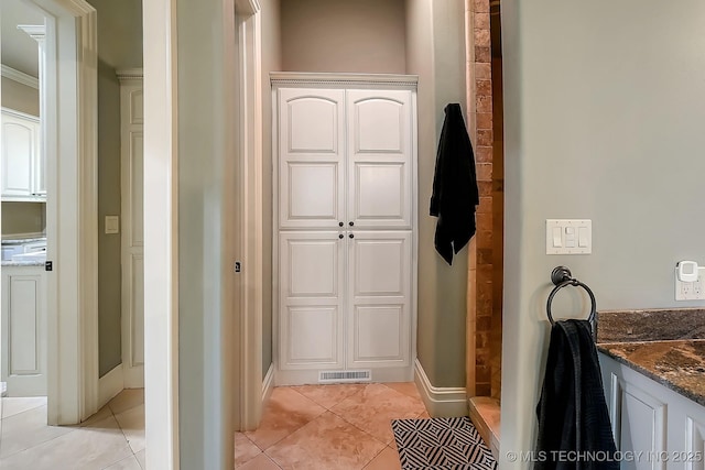 bathroom featuring tile patterned flooring, a stall shower, and baseboards