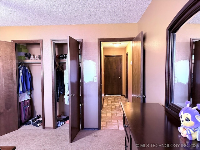 2902 Hilltop Ave, Muskogee, OK 74403 - carpeted bedroom featuring a textured ceiling and multiple closets