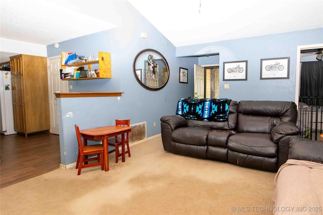 carpeted living room featuring lofted ceiling and baseboards