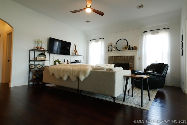 118 W 130th Pl S, Jenks, OK 74037 - living area featuring arched walkways, ceiling fan, dark wood finished floors, a fireplace, and baseboards