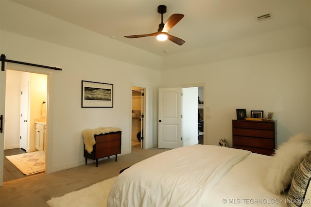 118 W 130th Pl S, Jenks, OK 74037 - bedroom with a barn door, light colored carpet, a spacious closet, connected bathroom, and baseboards