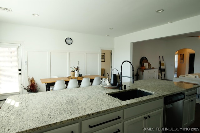 118 W 130th Pl S, Jenks, OK 74037 - kitchen with a sink, stainless steel dishwasher, arched walkways, light stone counters, and open floor plan