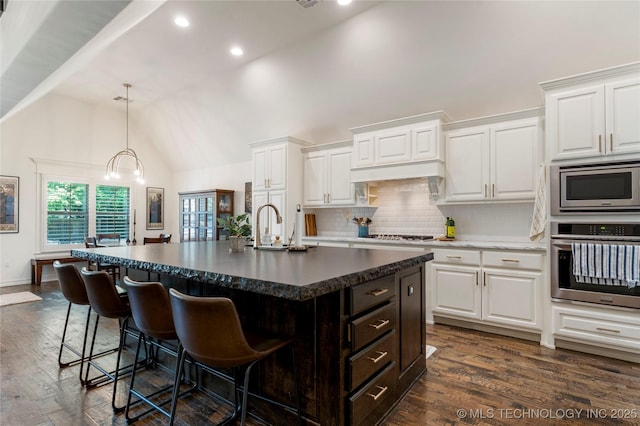 2835 E 104th St, Tulsa, OK 74137 - kitchen with appliances with stainless steel finishes, a breakfast bar area, white cabinetry, high vaulted ceiling, and recessed lighting