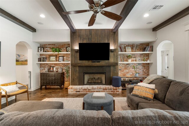 2835 E 104th St, Tulsa, OK 74137 - living room featuring arched walkways, beamed ceiling, wood finished floors, ceiling fan, and baseboards