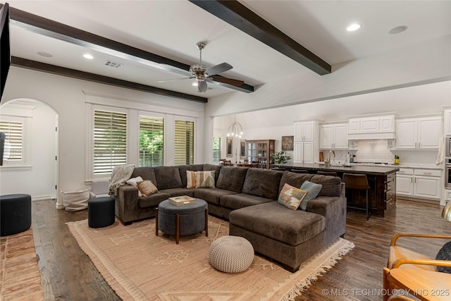 2835 E 104th St, Tulsa, OK 74137 - living area featuring a ceiling fan, beamed ceiling, arched walkways, dark wood-style flooring, and recessed lighting