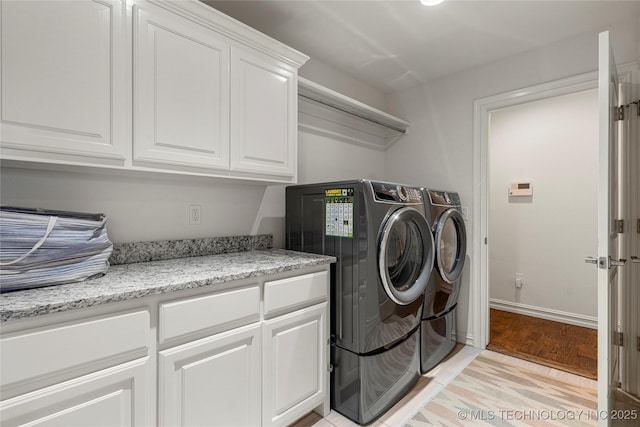 2835 E 104th St, Tulsa, OK 74137 - clothes washing area featuring cabinet space, washing machine and clothes dryer, light wood-style floors, and baseboards