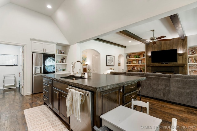 2835 E 104th St, Tulsa, OK 74137 - kitchen featuring a sink, arched walkways, dark countertops, stainless steel appliances, and built in features