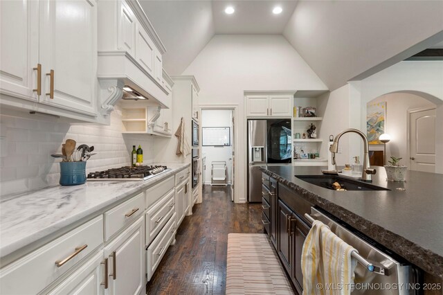2835 E 104th St, Tulsa, OK 74137 - kitchen featuring a sink, stainless steel appliances, open shelves, arched walkways, and white cabinets