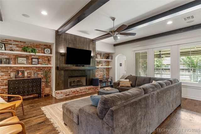 2835 E 104th St, Tulsa, OK 74137 - living room with arched walkways, beam ceiling, wood finished floors, a fireplace, and ceiling fan