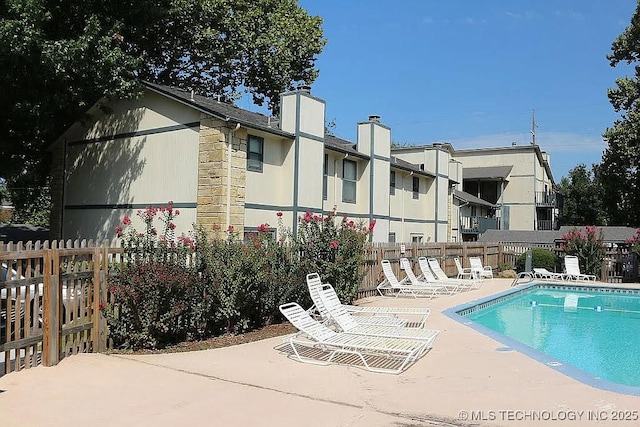5281 Nowata Rd Unit Q101, Bartlesville, OK 74006 - back of property featuring a patio, a community pool, and a chimney