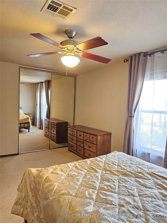 5281 Nowata Rd Unit Q101, Bartlesville, OK 74006 - carpeted bedroom featuring a textured ceiling and ceiling fan