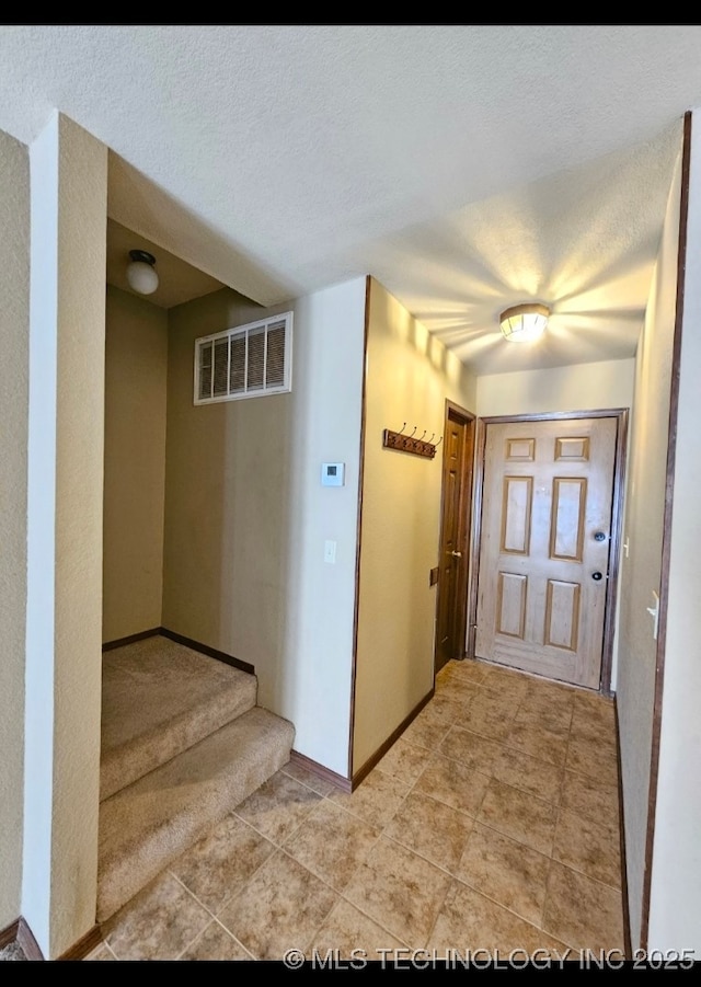 5281 Nowata Rd Unit Q101, Bartlesville, OK 74006 - foyer entrance featuring stairway, baseboards, a textured ceiling, and light tile patterned floors