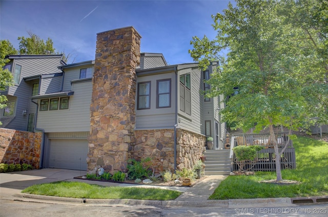 view of front of house with a chimney, driveway, stone siding, a garage, and stairway